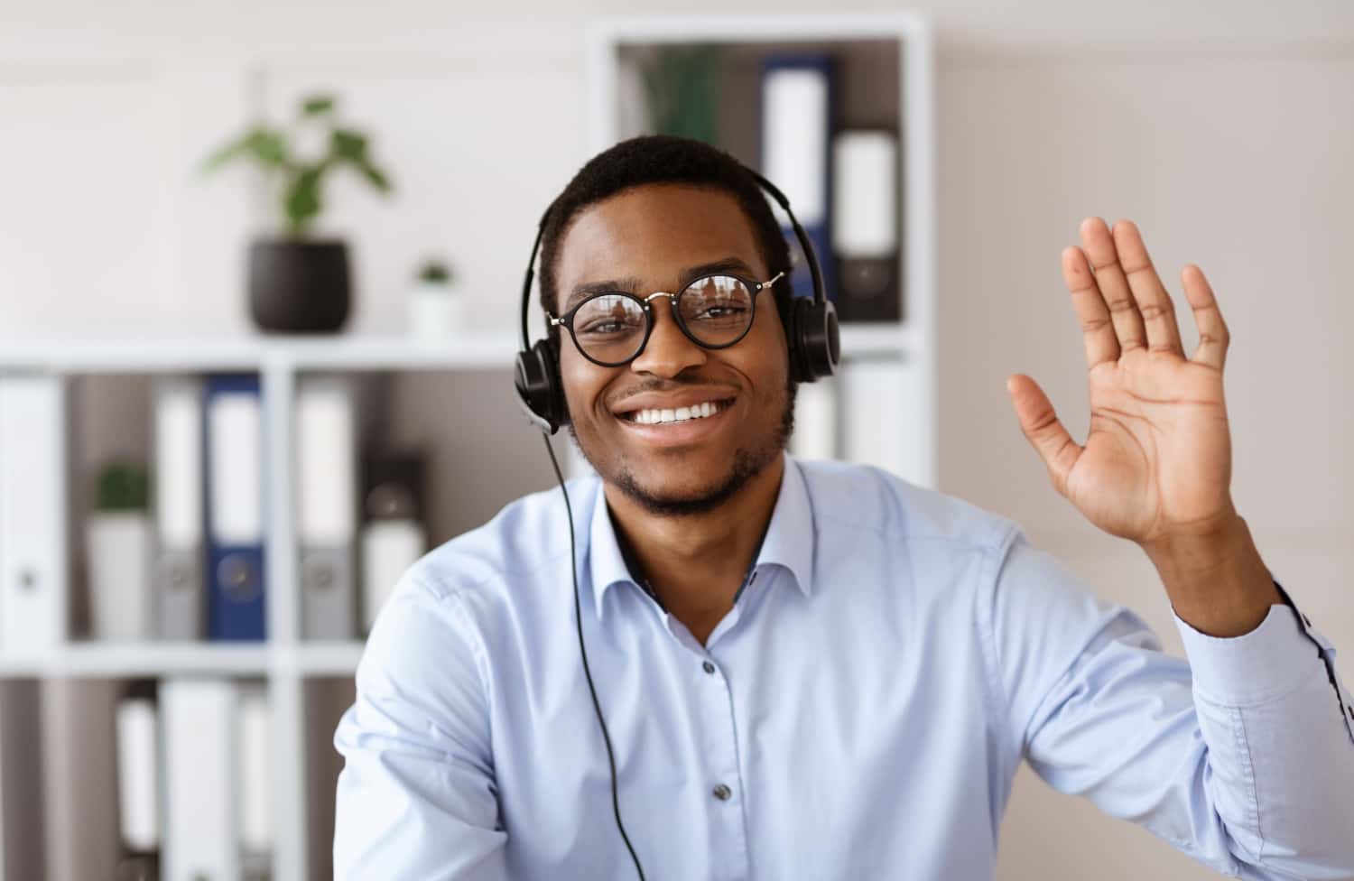 happy-black-consultant-with-headset-waving-at-came-2022-12-16-08-19-05-utc-min.jpg